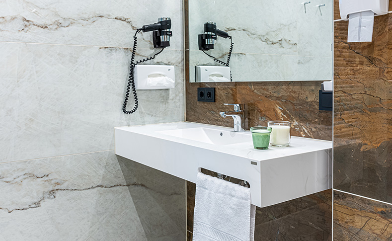 Helle und moderne Badezimmer mit ebenerdiger Glas-Duschkabine, Haarföhn und flauschig weichen Handtüchern